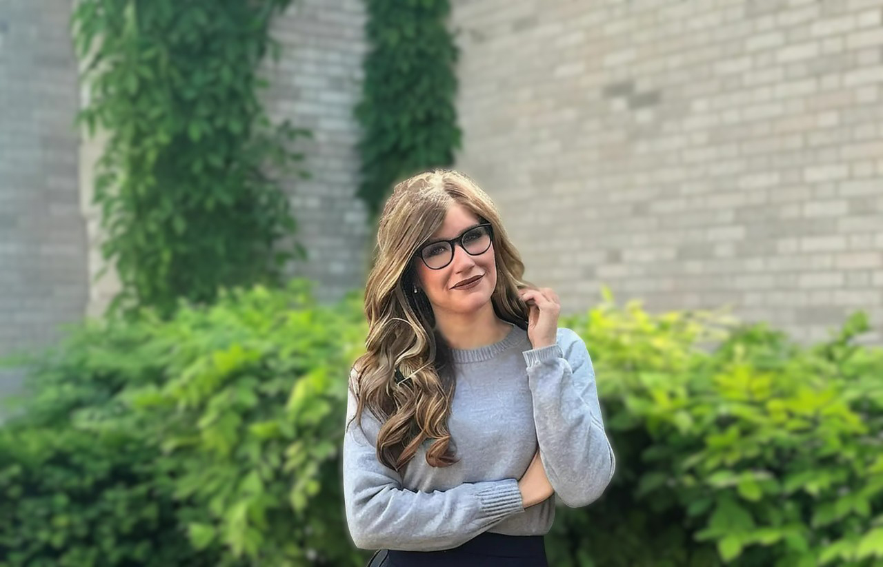 Lindsay Renaud, Windsor therapist, smiling outdoors with greenery in the background, reflecting warmth and a welcoming presence.